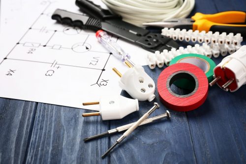 Electrician tools and schemes on wooden background