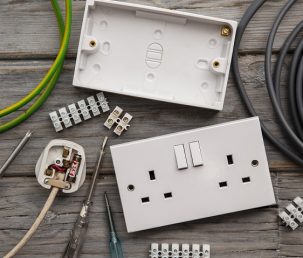 Electrical tools and equipment on a wooden background